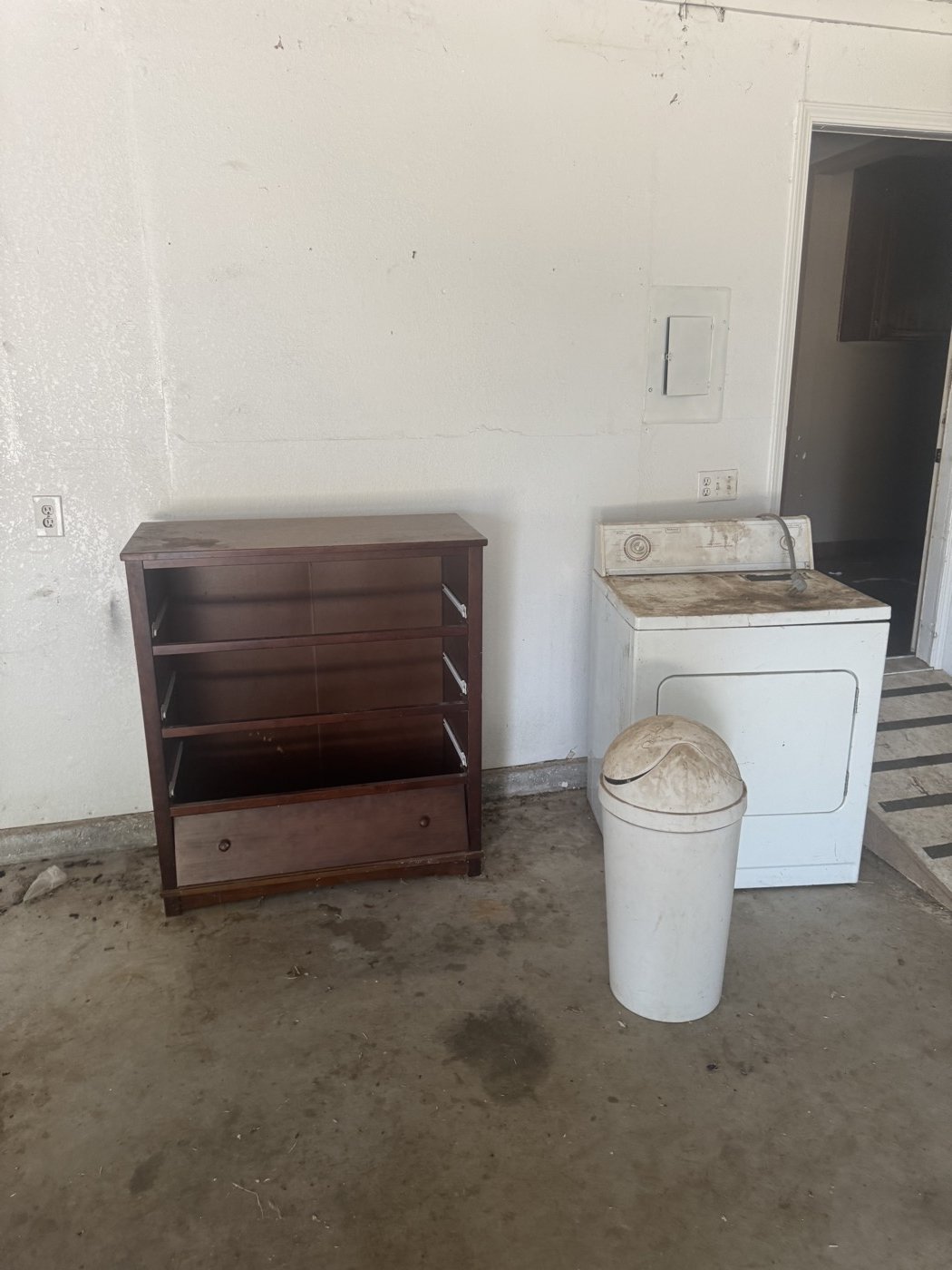 Before: garage with old dresser, washer, and trash can left behind