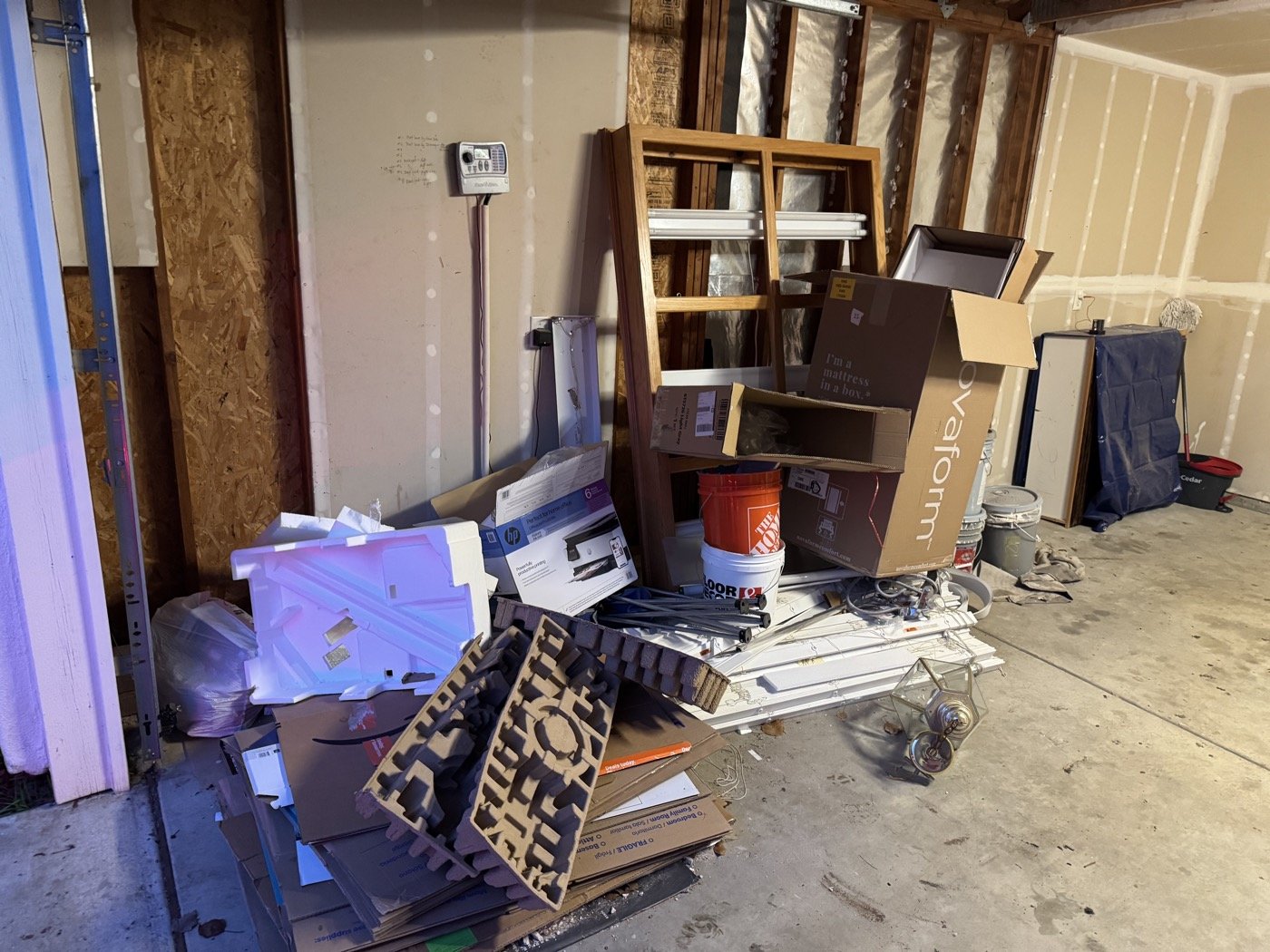 Before: garage filled with construction debris, boxes, and materials