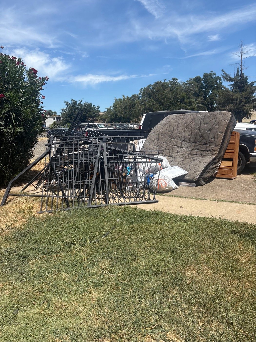 Before: large curbside pile with bed frames, mattress, and old furniture